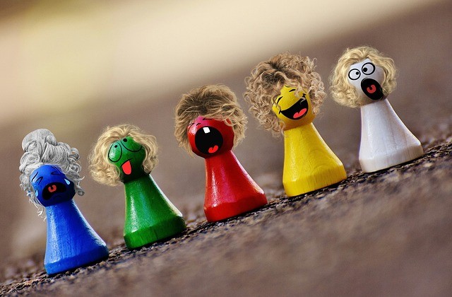 Row of multi-coloured wooden people with crazy outfits an d hair