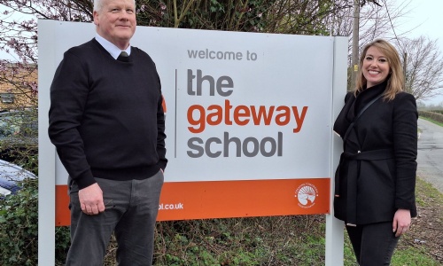Executive Headteacher Conor Renihan standing with Sarah Bool MP by the sign at the entrance to The Gateway School